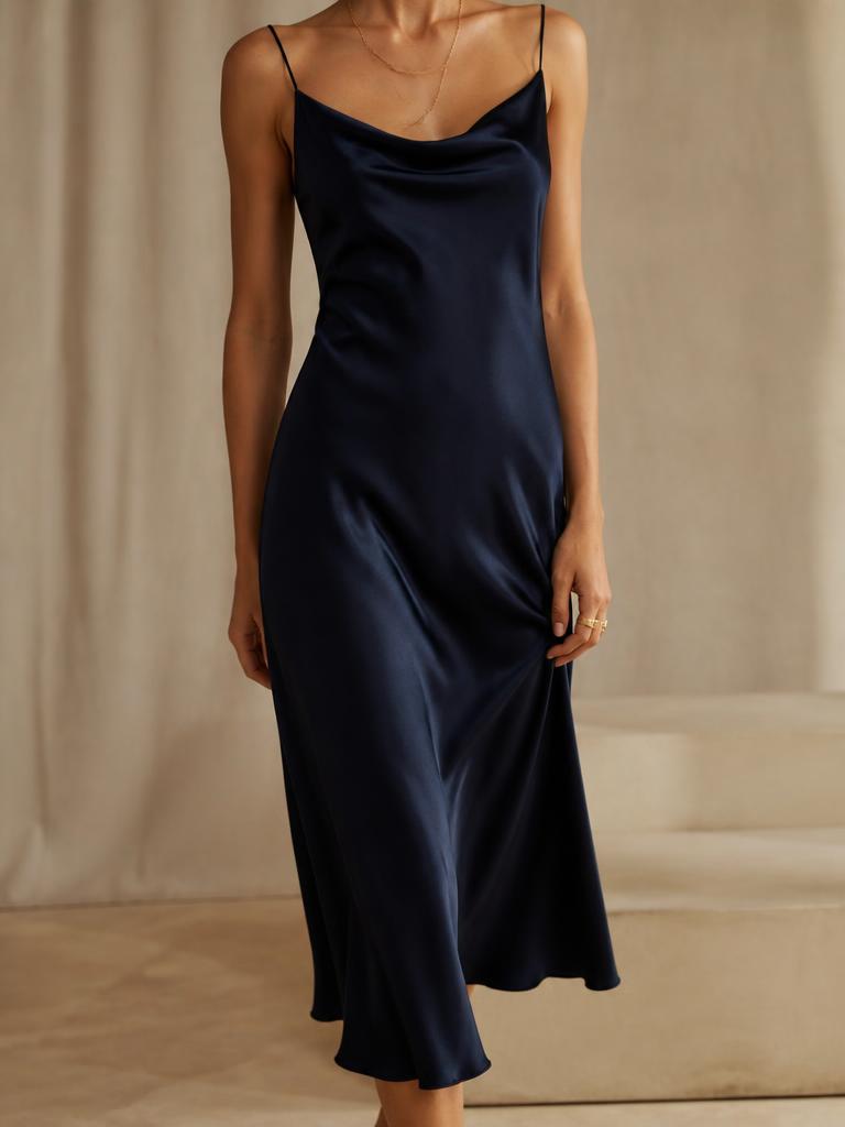 Model wearing an ink navy bias cut satin slip dress with fine straps